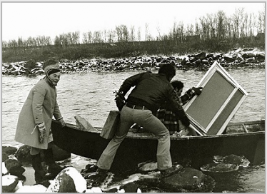 Photo of Bier Ante Ris'ten (left); Ronald Davis (center) with paint box and portable easel; and Stanley Roseman (right) with his canvases as they prepare to cross a river in a rowboat in Lappland, 1976. Photo courtesy of Myrdene Anderson.
